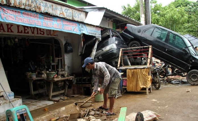 Warga tengah membersihkan sisa lumpur pasca banjir, yang melanda kawasan Pondok Gede Permai, Jatiasih, Bekasi, Jawa Barat pada Kamis (2/1) lalu